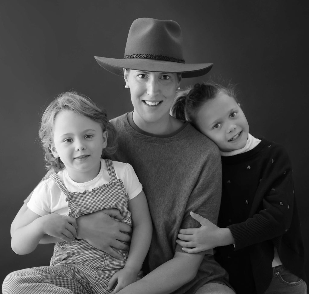 Black and white photo of Catherine Thompson owner of the baby sleep consultancy Completely Baby based in Sydney, posing with her girls