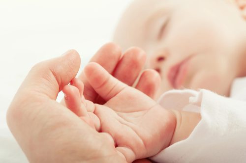 baby having hand held as its been waking up every 2 hours