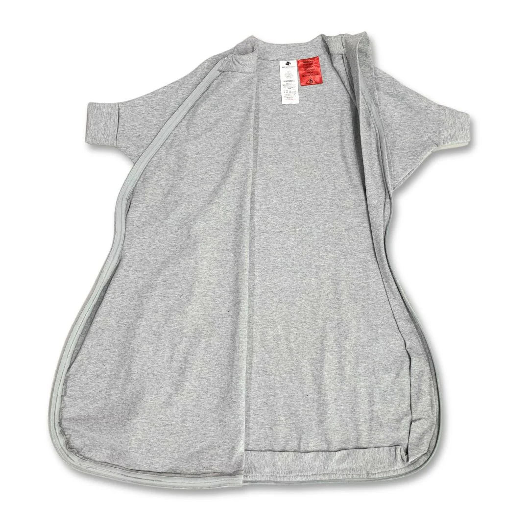 A grey, short-sleeved, zip-up wearable blanket or sleep sack is laid open and flat, showing the interior and tags near the neckline against a white background—perfect for any Baby Loves Sleep Hands In & Out Sleep Sack review.